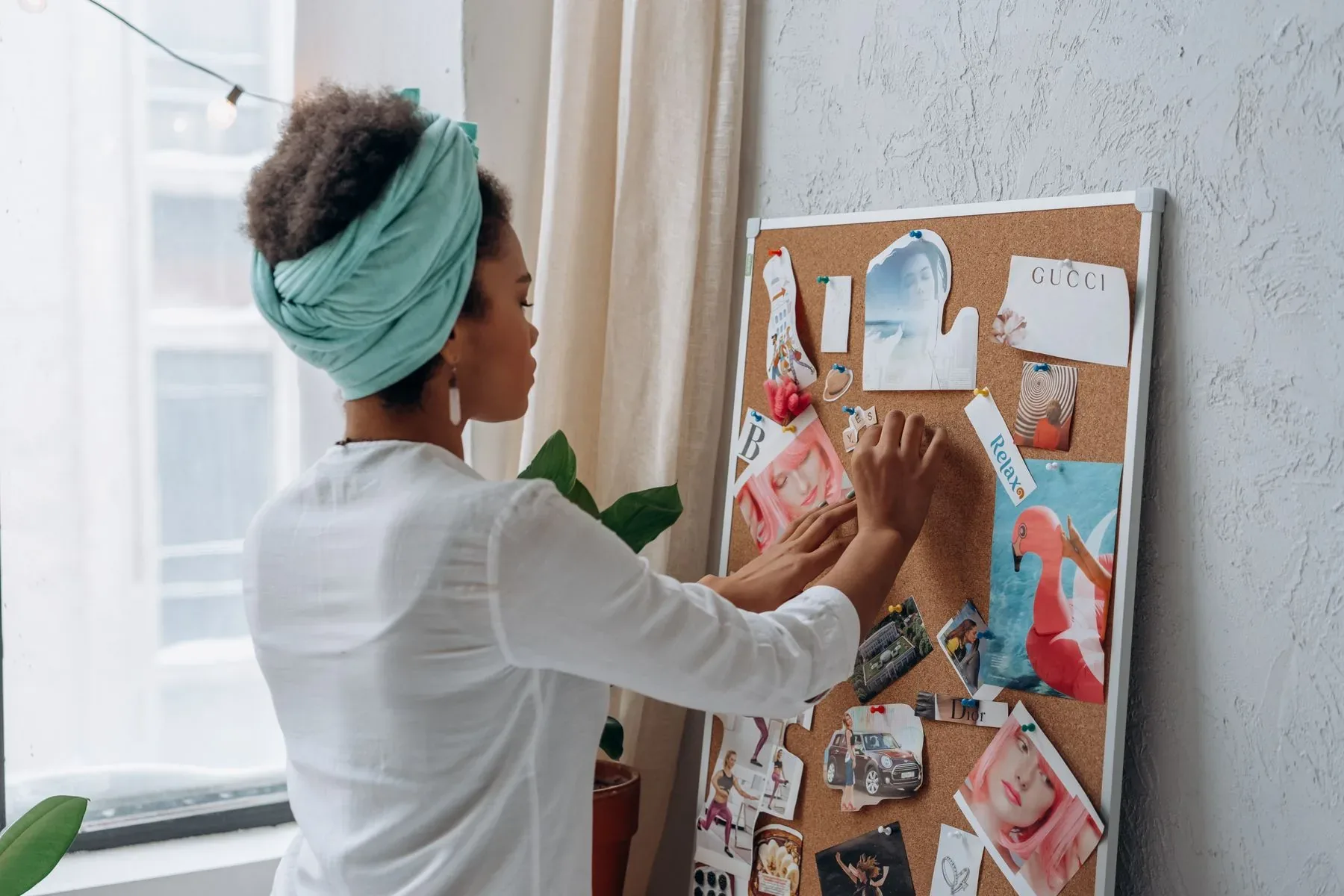 A woman arranging ideas on a creative vision board